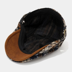 Detail view of plaid newsboy cap with breathable mesh lining and metal adjustable strap buckle