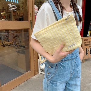 Portable yellow checkered seersucker makeup bag with zipper and wave texture design