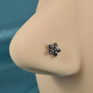 L-shaped flower nose stud with black zircons on a silver-tone metal body worn on a model