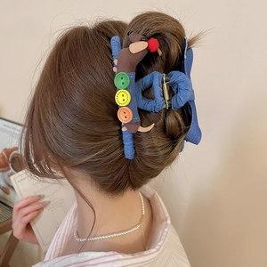 Gros plan détaillé d'une pince à cheveux en denim bleu avec décor de chien en peluche