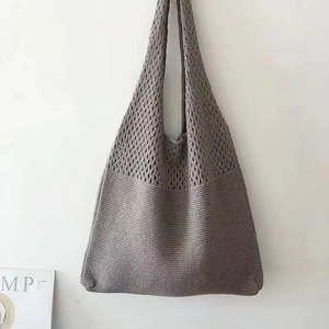 Detailed macro view of the grey knitted tote bag showing intricate hollow mesh pattern