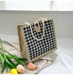 Detail of canvas tote with houndstooth pattern, rope handle and wooden button closure