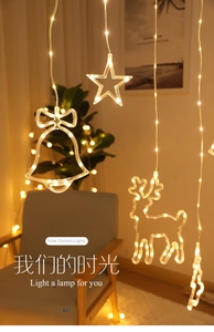 Detail of warm white LED curtain lights with deer and star pendants for home decor
