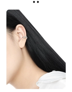Detailed close-up of a silver S925 sterling silver ear cuff with twisted rhinestone design