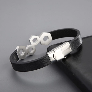 Detail of black leather braided bracelet with hexagonal stainless steel links and clasp