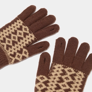 Detailed view of brown knit gloves with geometric patterns and touchscreen thumb opening