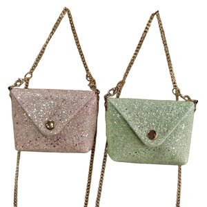 Pink and green glitter mini handbags with gold chains on white background