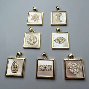 Macro shot of seven square gold pendants with shell inlay and micro-pave celestial motifs