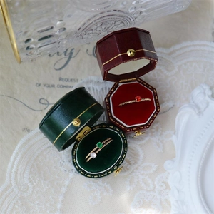 Detailed shot of sparkling 18k gold-plated slim rings in vintage velvet jewelry boxes