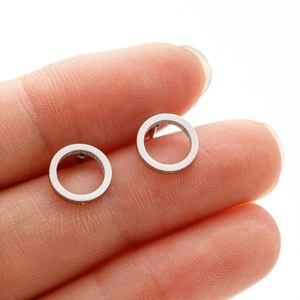 Minimalist silver stainless steel hoop earrings shown on a finger for size reference
