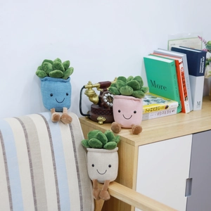 Plush succulent plant toys with smiley faces in colorful pots as home decoration