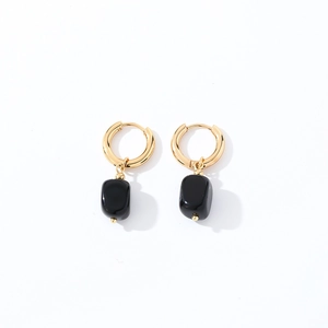 Detailed view of geometric black natural stone pendants hanging on gold circular hoops
