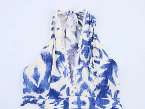 Détail de robe dos nu bohème avec imprimé ikat bleu et bordures en dentelle blanche