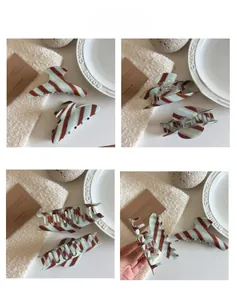 Detail view of large acetate hair claws with vintage brown and blue diagonal stripes
