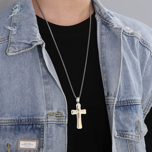 Gros plan d'un pendentif double croix pour homme style hip-hop avec finition or et argent