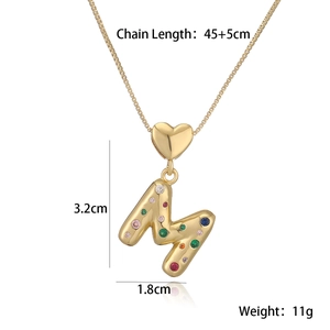 Detail of 18K gold letter M pendant with colored stones and heart decor, 3.2cm height