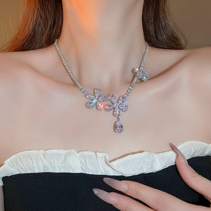 Close-up of a silver flower necklace with sparkling zircon and a water drop pendant