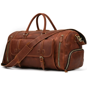 Detail of vintage leather travel bag showing texture, dual handles and side pocket