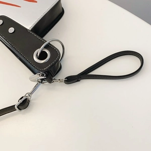 Macro view of wide strap and silver metal hardware on creative cleaver crossbody bag