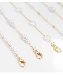 Detail of elegant gold eyewear chain with white baroque pearls and lobster clasps