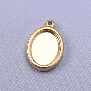Macro detail of a 18k gold plated oval pendant base for DIY jewelry making and necklaces
