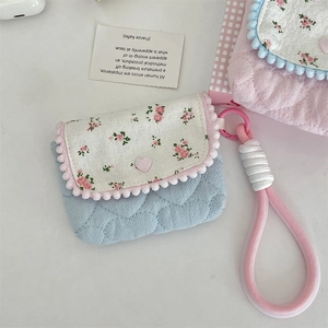 Detail of floral quilted cotton case with heart button and pink woven lanyard