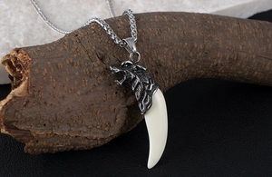 Dettaglio di una collana a testa di lupo argento con pendente a dente su ramo