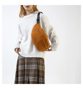 Modello che indossa un marsupio in nylon zenzero come borsa da petto a tracolla in studio