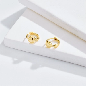 Minimalist gold ball hoop earrings with high-polish finish on white geometric pedestals