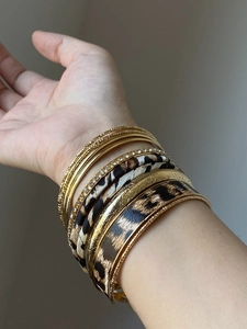 Detail view of 10-piece bohemian gold bracelets set with leopard print fabric and crystals
