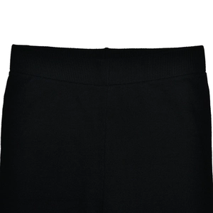 Detail of elastic waist on black knitted pants featuring soft ribbed fabric texture