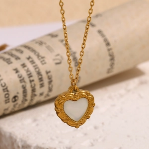 Detail showing vintage heart pendant necklace in 18K gold finish with white shell inlay