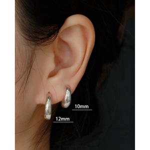 Detail showing 10mm and 12mm S925 sterling silver hoop earrings on model's ear