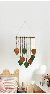 Détail d'une tapisserie macramé faite main avec des feuilles en coton coloré et perles bois