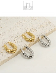 Detail of twisted U-shaped hoop earrings in gold and silver finish titanium steel
