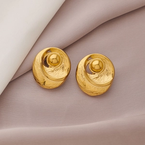 Detailed shot of gold hammered C-shaped stud earrings with central beads on silk