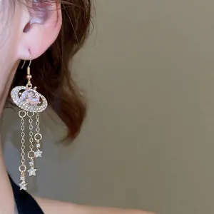 Sparkling pink oval planet earrings with gold star tassels for an elegant palace style look