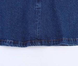 Dettaglio dell'orlo con doppia cucitura e della trama del tessuto denim blu scuro