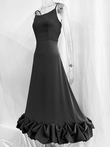 Detail of elegant black strapless long dress with ruffled hem and slim fit silhouette