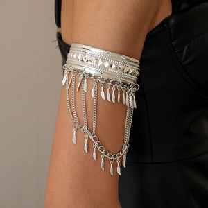 Detailed close-up of silver arm cuff featuring fringe chains and metal feather charms