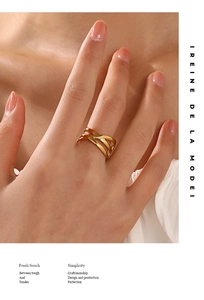 Detailed view of a gold-plated multi-layer crossover ring worn on a finger