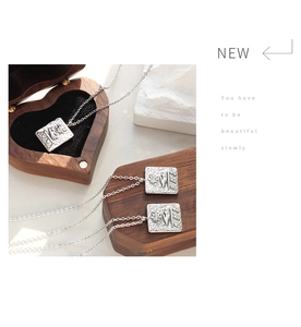Macro detail of Egyptian relief square pendant with sun motif in a heart-shaped wooden box