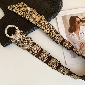 Detailed macro view of leopard print leather belt with rhinestone butterfly buckle and gems