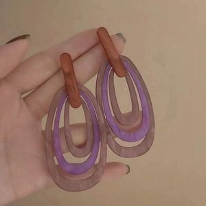 Detailed view of handmade vintage resin hoop earrings featuring brown and purple oval charms