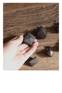 Detail of vintage cast iron drawer handles with matte finish on dark wood background