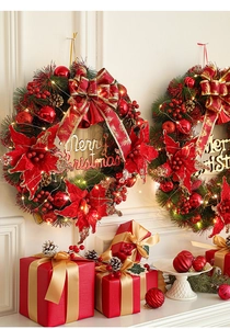 Close-up of lighted Christmas wreath with red flowers and golden Merry Christmas sign