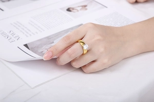 Fashionable golden titanium steel ring with round zircon worn on a model over a magazine
