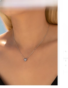Detail of S925 silver heart necklace with blue stones and crystals on model
