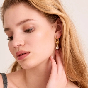 Dettaglio orecchino con perla barocca e placcatura in oro 18K spazzolato su modella