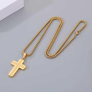 Detail of a gold stainless steel cross pendant featuring a polished box chain link necklace